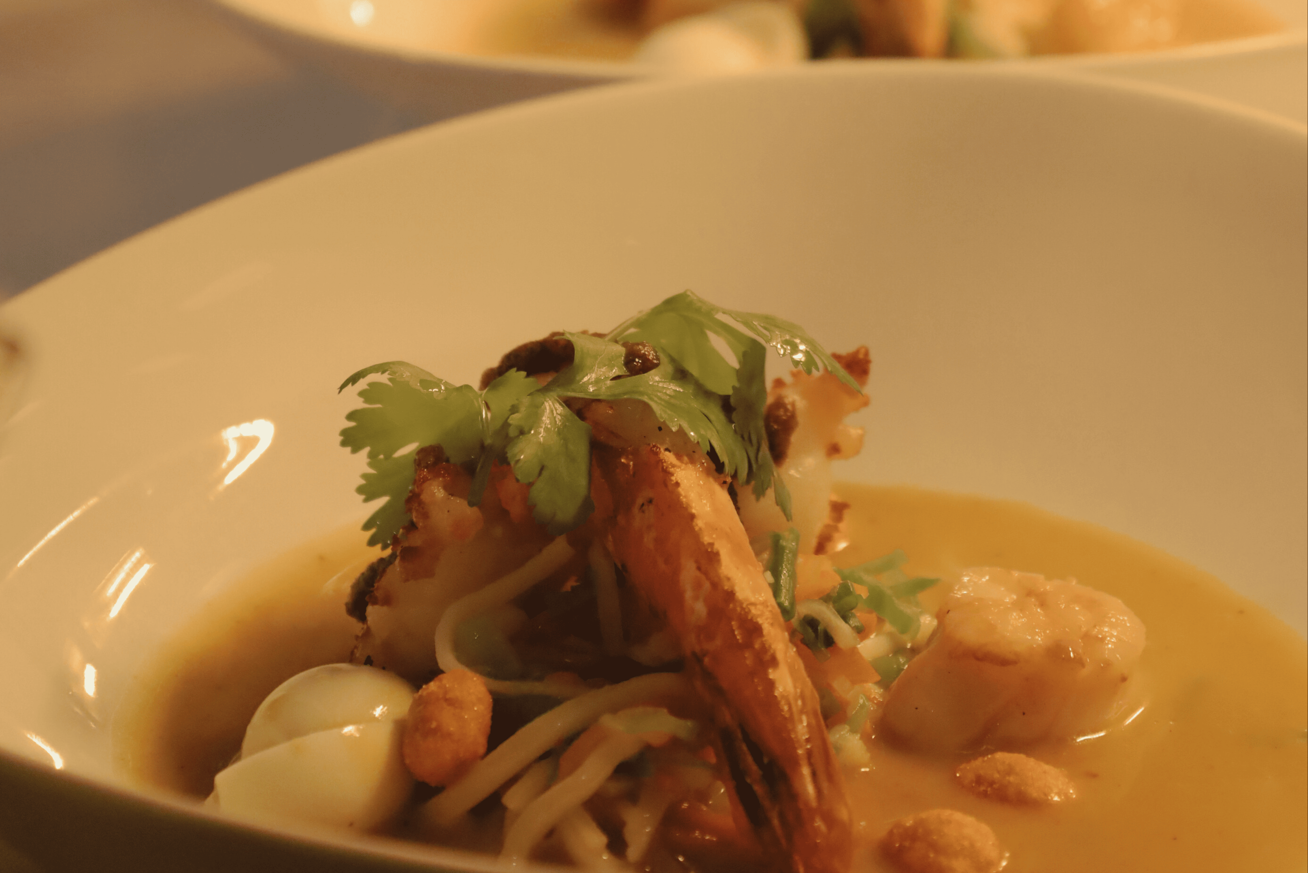 SuppeWilkes-Laksa-süss-scharfe-Zitronengras-Koriander-Chili-Currysuppe-mit-Wachtelei-Riesengarnele-und-Jakobsmuschel©Christina-Hertrich-e1707908756994